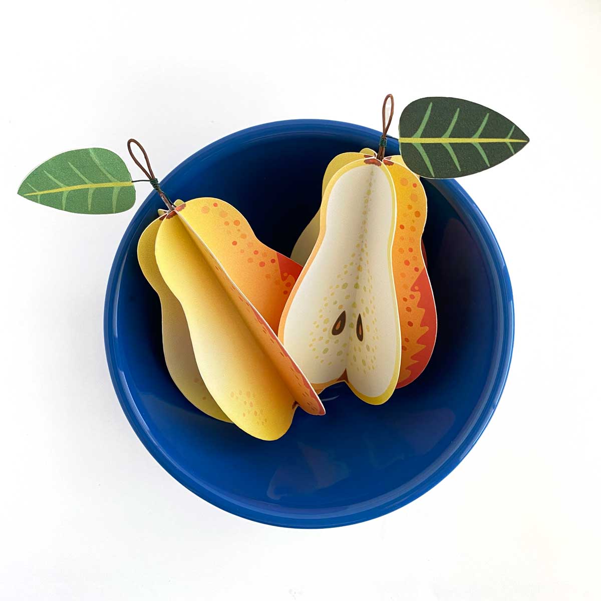 Handmade Paper Pears Mozaic Studio, shown in a blue latte bowl