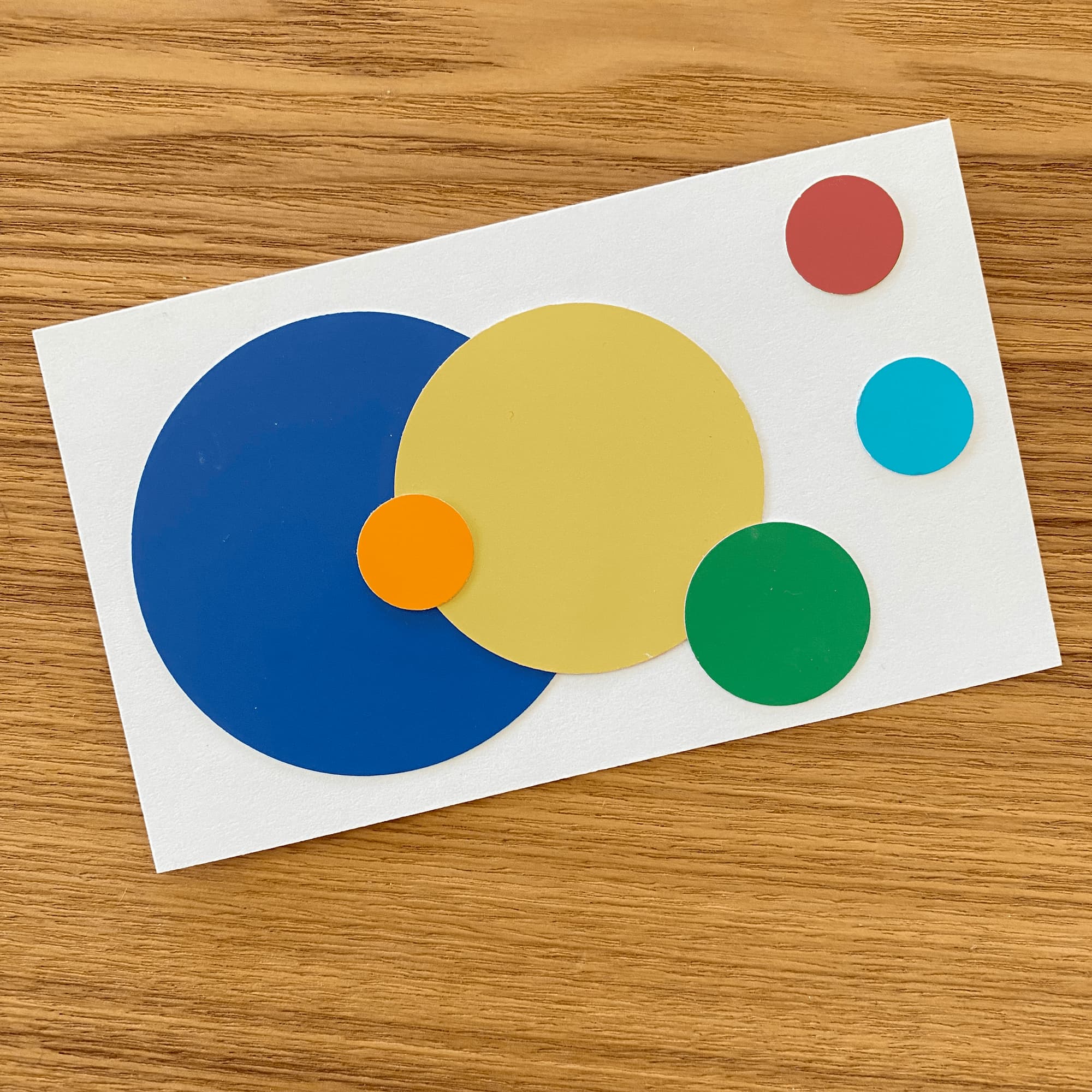 collage on index card with various sizes of circles in blue, red, green and yellow.