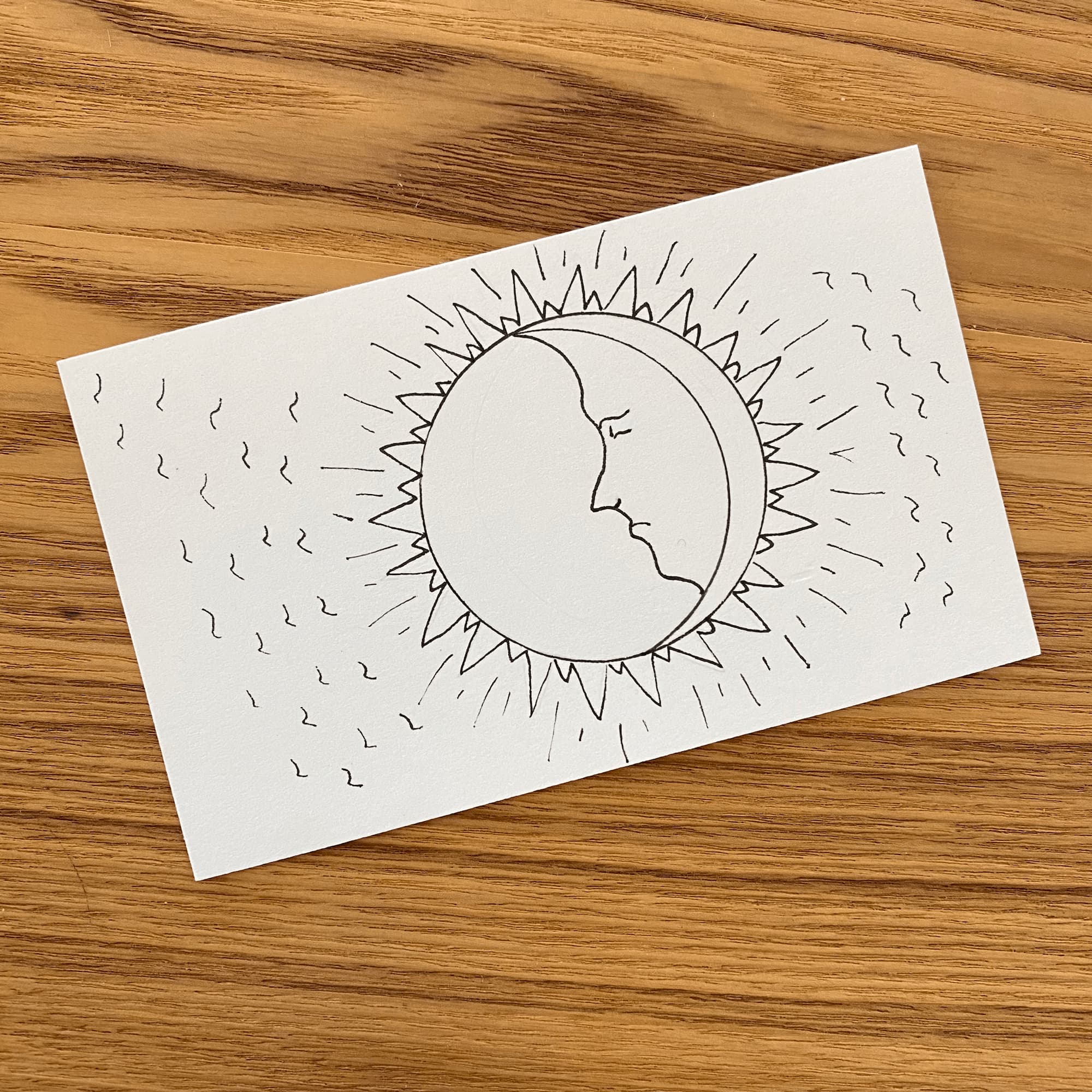 ink sketch of the sun with a man's profile and sun rays projecting outwards.