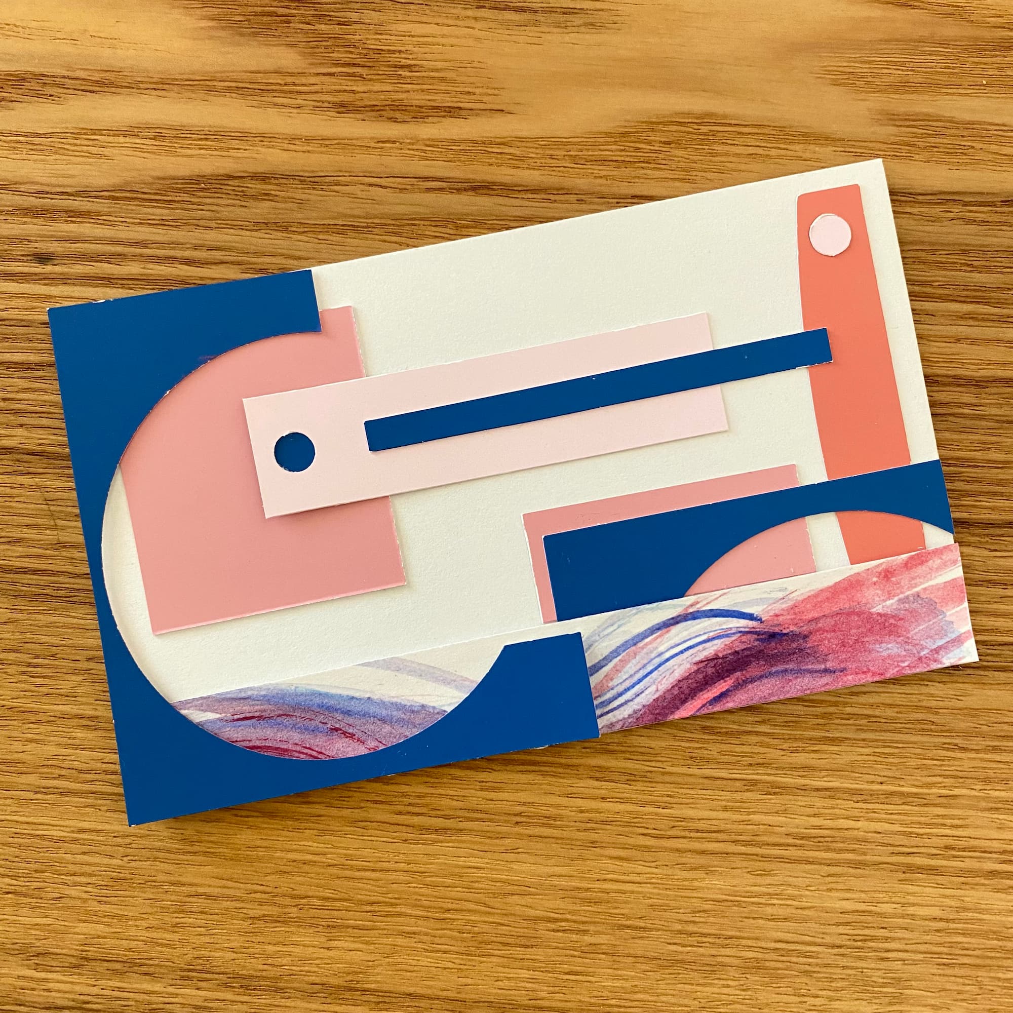 geometric collage with colored paper in pink, coral and navy blue