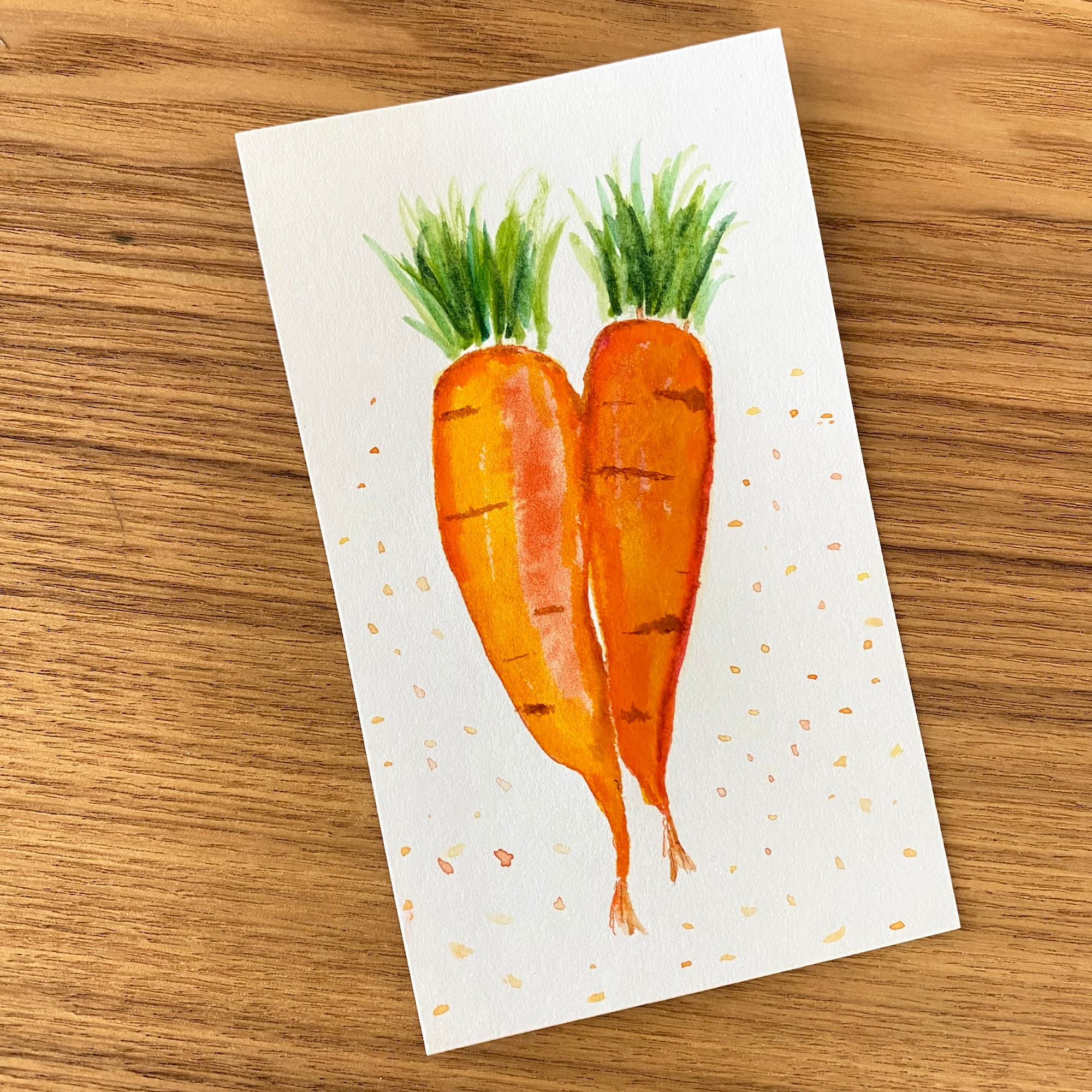 two watercolor carrots side by side