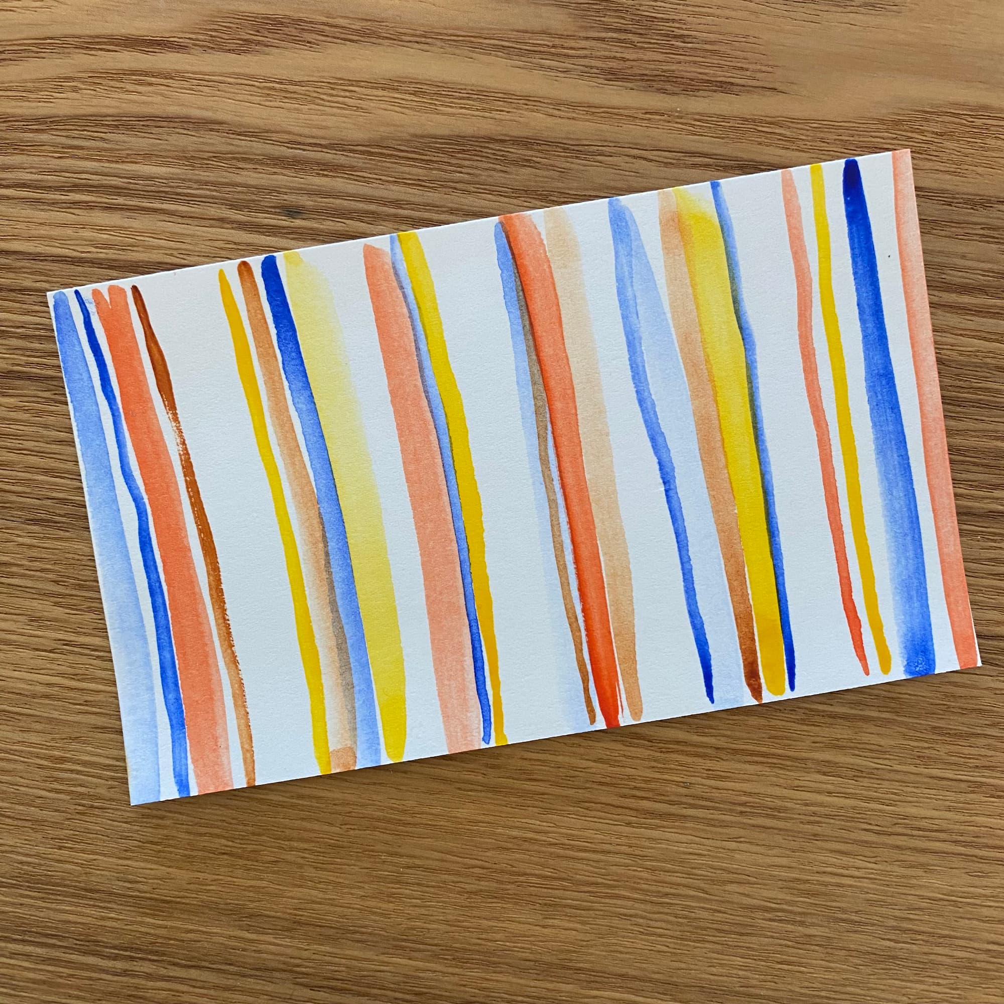 watercolor painting done with vertical stripes of blue, peach and yellow.