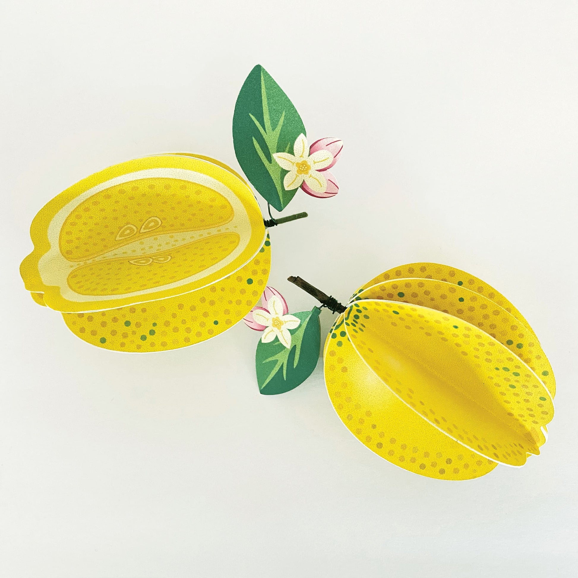 2 handmade paper lemons on a white background