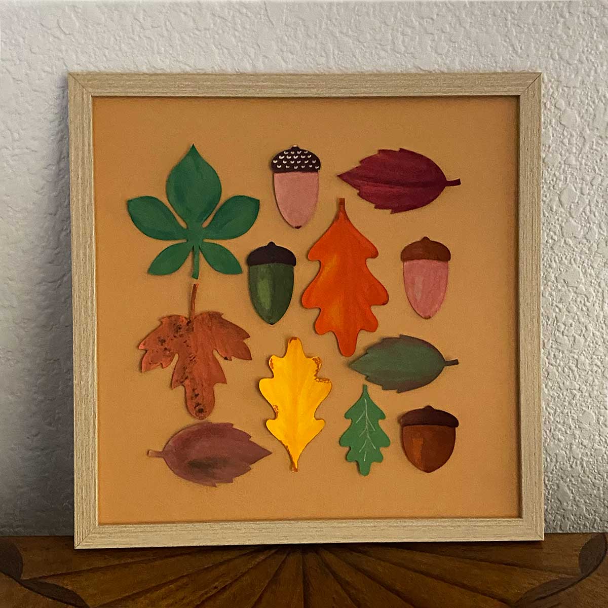 Framed artwork with paper leaves  and acorns to showcase a Cakewalk DIY Paper Craft tutorial.