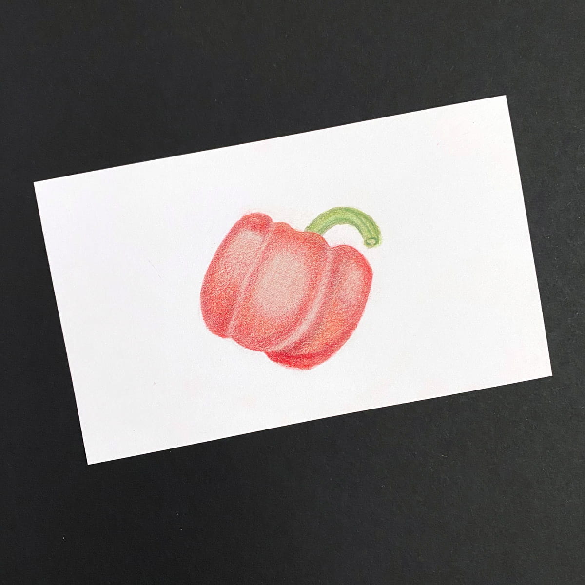 Index card with red bell pepper illustration done with colored pencils on a black background by Mozaic Studio for ICAD 2025.