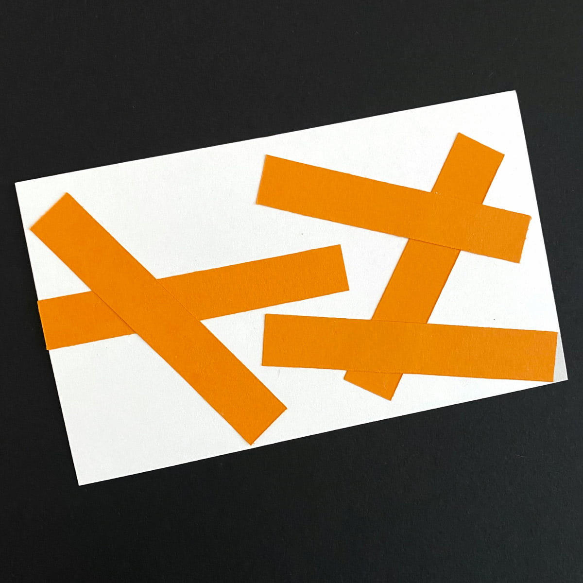 Index card with abstract collage of strips of orange colored paper on a black background by Mozaic Studio for ICAD 2025.