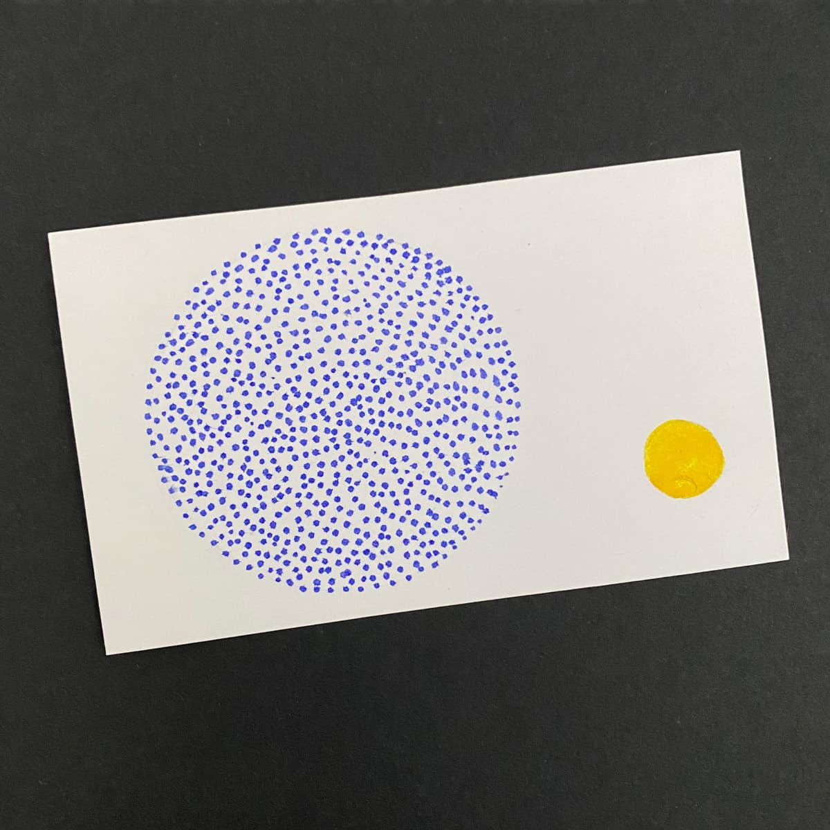 Index card with abstract drawing of a large circle made with purple dots and a small circle made with yellow ink on a black background by Mozaic Studio for ICAD 2025.
