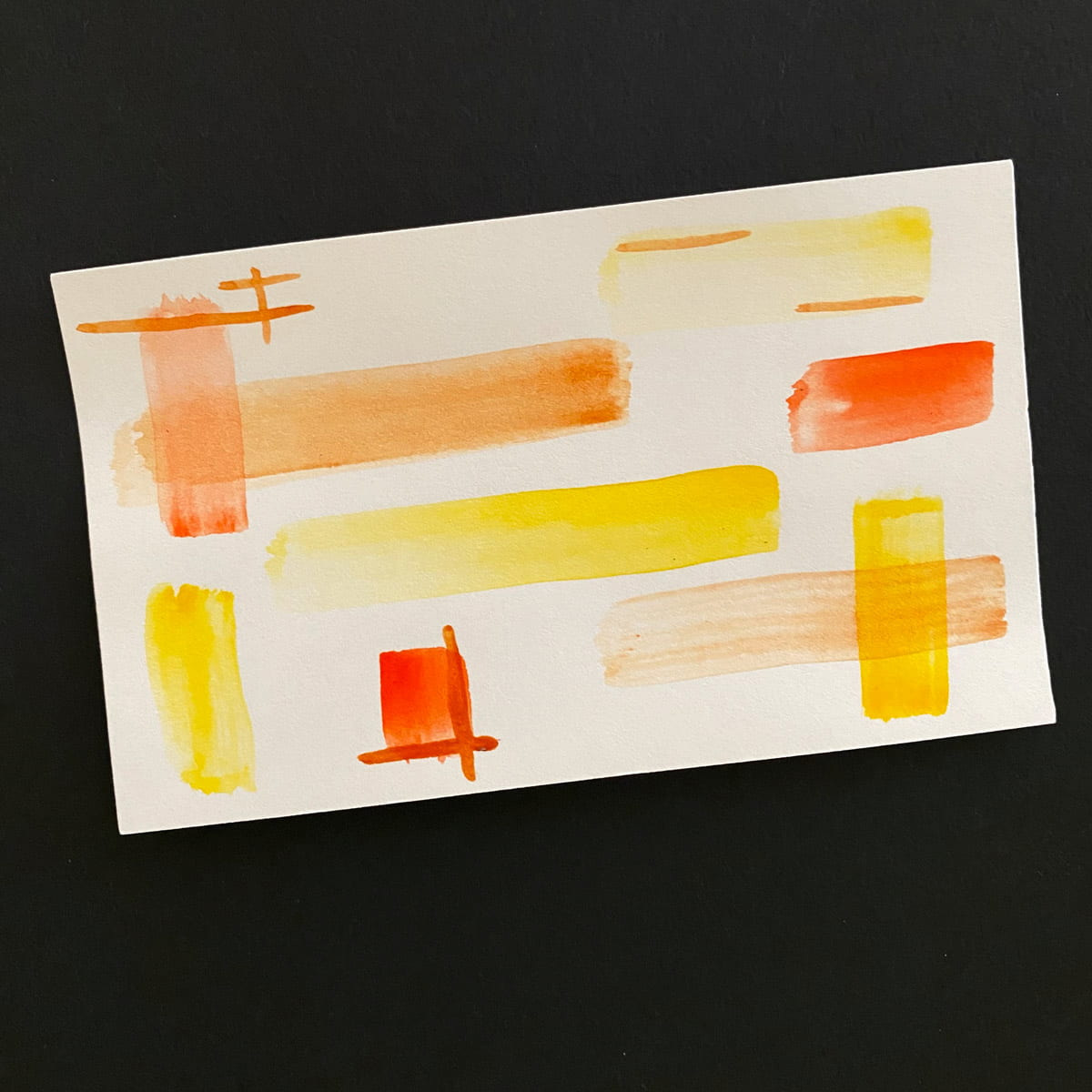 Index card with watercolor painting in yellow, orange and brown on a black background by Mozaic Studio for ICAD 2025