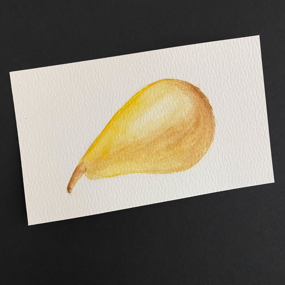 Index card with a watercolor painting of a Bartlett pear on a black background by Mozaic Studio for ICAD 2025