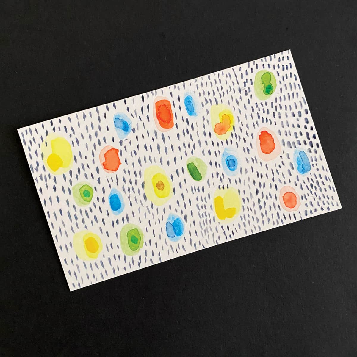 Index card with an abstract painting of colored shapes and black marks s made with watercolors on a black background by Mozaic Studio for ICAD 2025