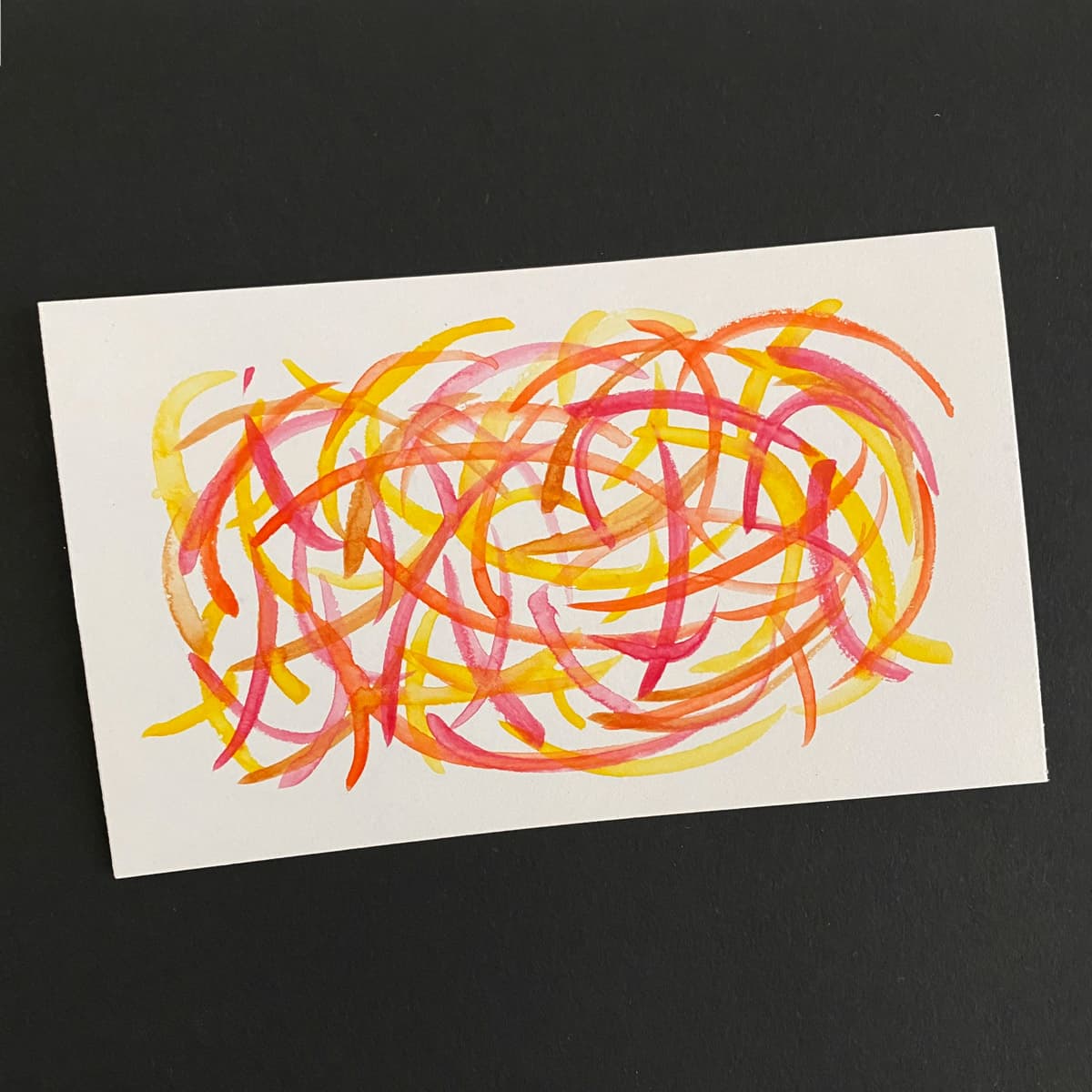 Index card with an abstract watercolo of overlapping, multicolored strokes in red, orange and yellow on a black background by Mozaic Studio for ICAD 2025