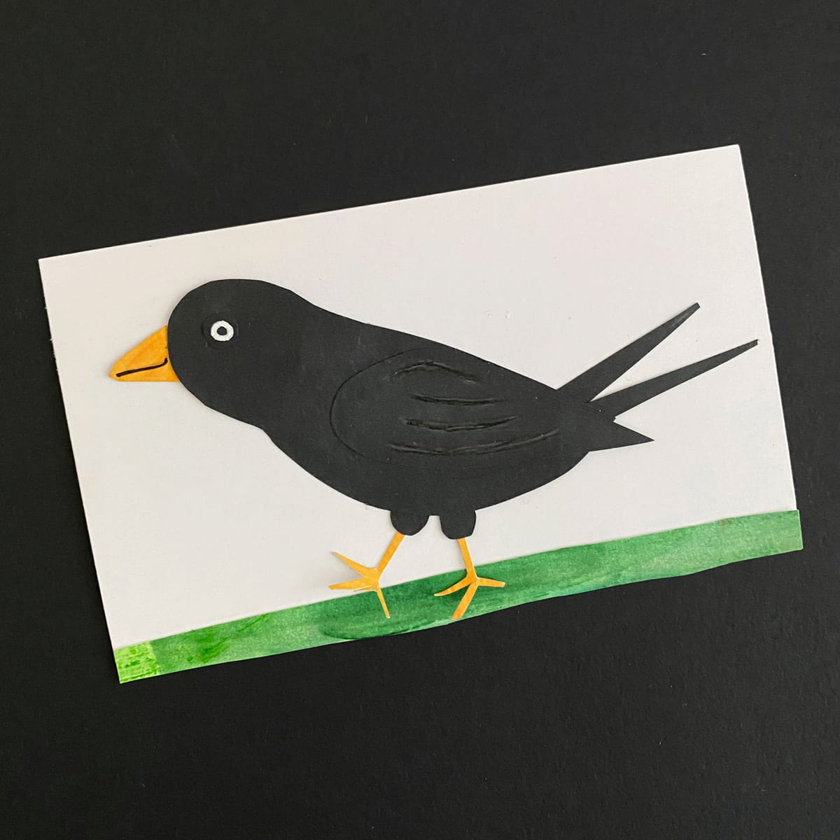 Index card with a paper collage of a black bird on a black background by Mozaic Studio for ICAD 2025
