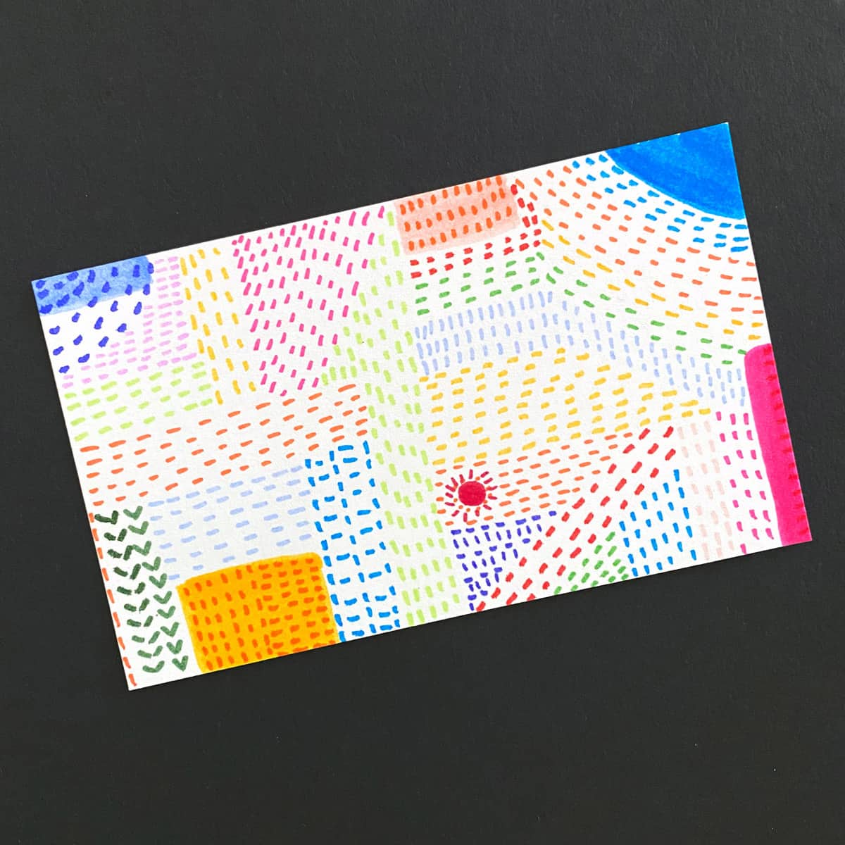 Index card with abstract shapes made with mark-making using colored markers on a black background by Mozaic Studio for ICAD 2025.