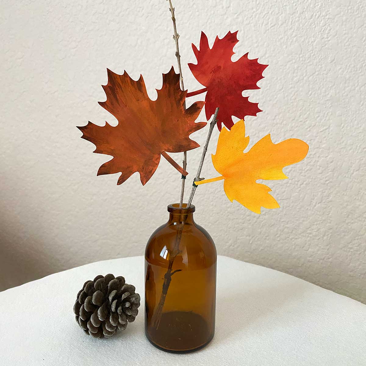 Autumn-themed decoration with paper leaves in an amber vase to showcase Cakewalk DIY Paper Craft tutorial.
